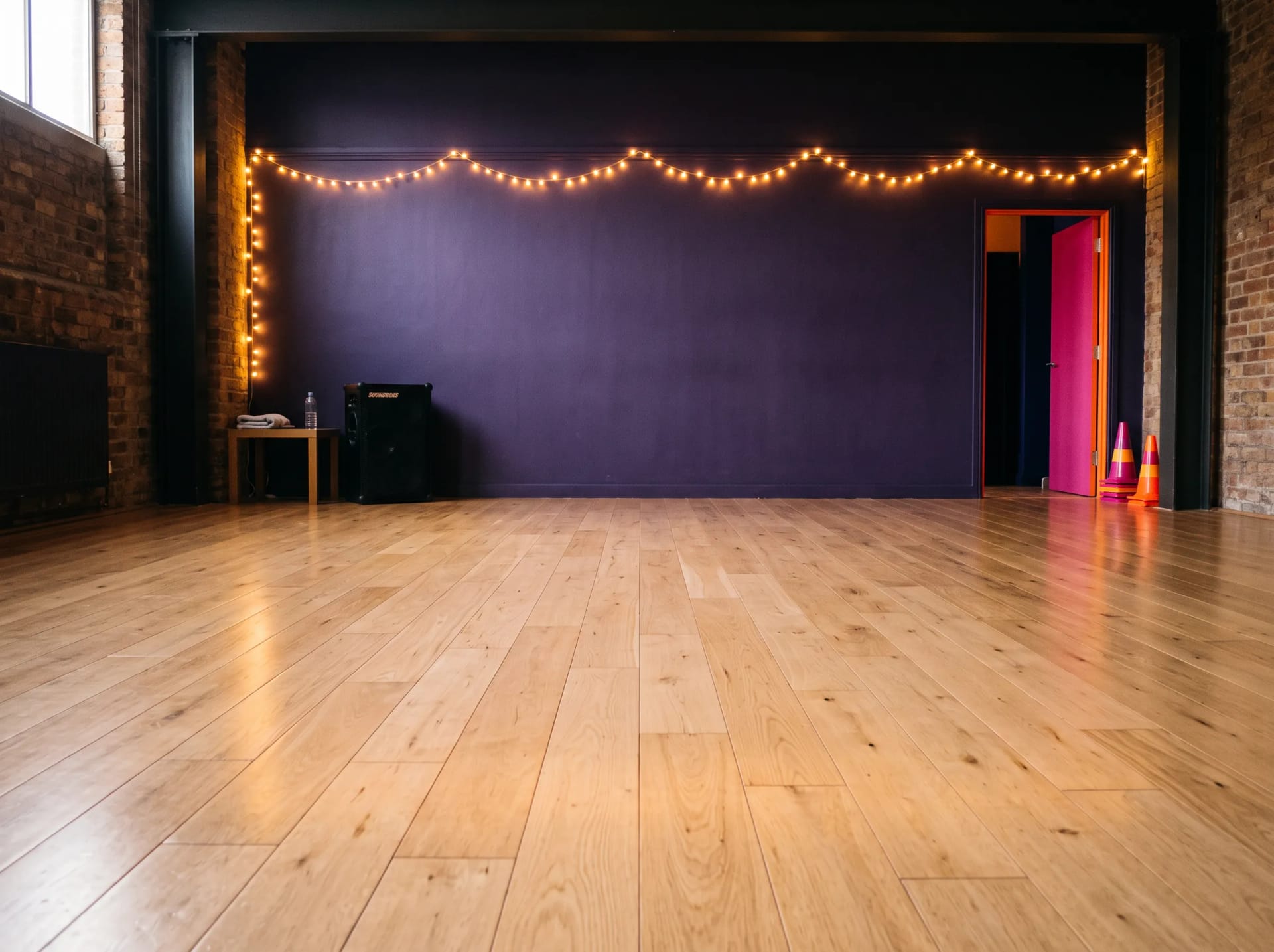 The empty Pulse and Shine studio off Rye Lane in Peckham, London, wooden floor and bright colour pops before class